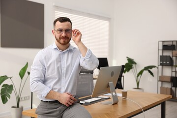 Portrait of handsome businessman at workplace in office