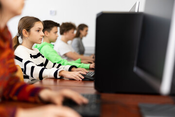 Teacher together with students conduct a lesson on computer education