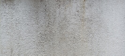 Rough White Cement Wall with Subtle Stains and Texture. Close-up of rough white cement wall surface with subtle dirt marks and gritty texture. Ideal for backgrounds or industrial design