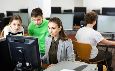 Fototapeta premium Teacher helping young student in computer class in university