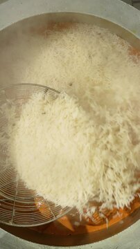 Boiled rice being layered in handi to prepare authentic Hyderabad chicken Dum biryani
