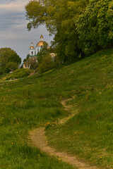 The way leading to the temple. The path along the green bank of the Western Dvina, leading to the Epiphany Cathedral in Polotsk, Belarus.