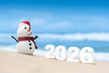 A Snowman on a beautiful beach with large 2026 numbers set in the background