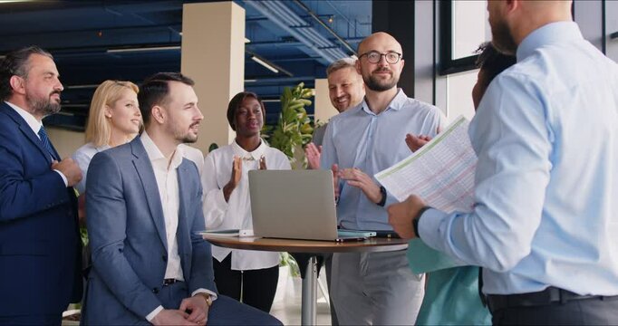 Businessman conducts a professional work meeting for team of colleagues in the office. Business group session focuses on teamwork through effective communication and collaboration between people.