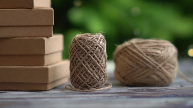 Preparing for Christmas. Wrapping holiday gifts. Gift boxes and natural twine on a Christmas tree and lights