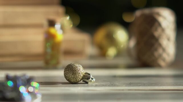 Holiday decor. Packing holiday gifts. Gift boxes, silver bow and Christmas gold balls against the backdrop of the Christmas tree and golden bokeh