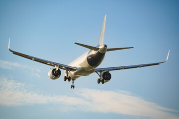 Rear view of an approaching passenger airplane preparing to land at the airport.