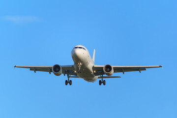 Passenger airplane preparing to land. Blue background.