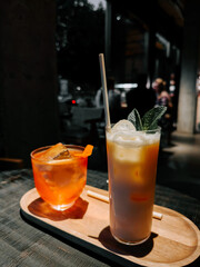 Evening cocktails served on a wooden tray in a vibrant outdoor setting