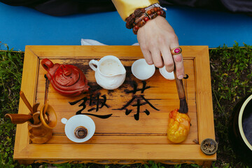 Chinese tea ceremony. Top view of the tea set. Male hand with a brush