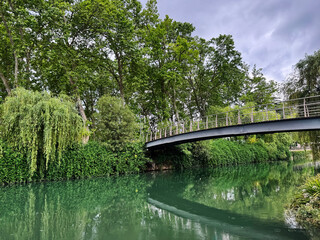 Scenic riverside view with footbridge surrounded by lush greenery