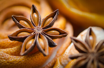 Close-up of a star anise pod with vivid texture and detail set against dried orange peel background