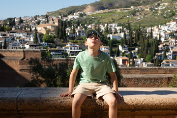 Young boy spitting water in summer day