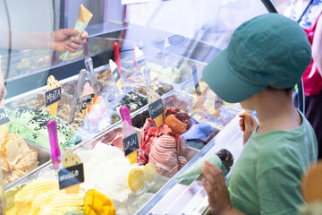 Little boy choosing ice cream flavor at gelato shop
