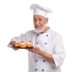 Professional pastry chef with delicious profiteroles on white background