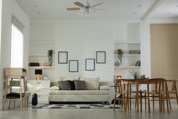 Fototapeta premium Comfortable sofa, table, chairs and dresser indoors. Interior design