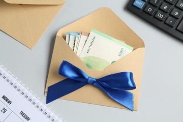 Money bonus. Envelope with euro banknotes on light grey background, flat lay