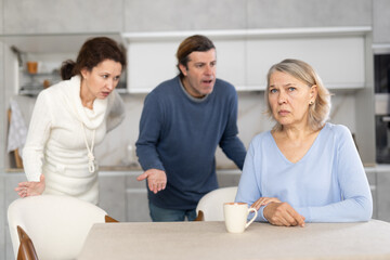 Married couple shouts at elderly mother. Family conflict between spouses and mother-in-law.