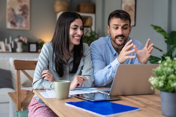Young intelligent innovative hipster couple presenting their startup new business idea via video call on laptop computer, working at home, talking to potential investor. Modern technology innovation.