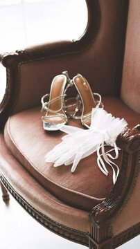 White gloves and sandals are lying on a chair. The concept of preparing for a wedding. Morning of the bride