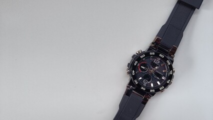 A modern and rugged black sports chronograph watch with a silicone strap, isolated on a clean white background with copy space.