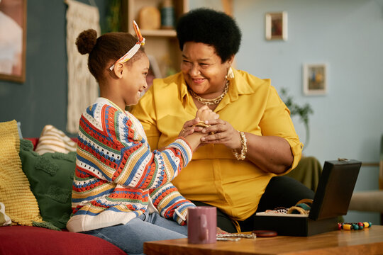 Smiling Grandmother and Granddaughter in Living Room