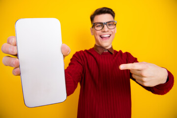Cheerful Young Man Showing Smartphone Screen Against Bright Yellow Background