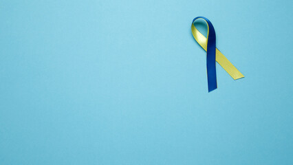 Symbolizing World Down Syndrome Day. A yellow and blue awareness ribbon