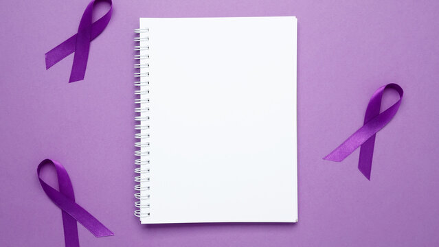 Purple Epilepsy Awareness Day, purple ribbon held, symbol of support. Mock up notebook