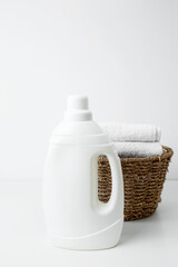 Laundry detergent branding mock up and basket filled with clean white towels. Household cleaning and hygiene concept packaging