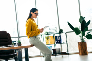 Modern businesswoman reviewing documents in a stylish office workspace with natural daylight