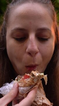 Urban food scene in Sofia Bulgaria as a woman enjoys her lunch with a handheld falafel wrap in a casual setting