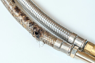 Burst braided connector hose for a faucet, isolated on white background compare with a new one