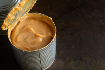 Fresh dulce de leche made from canned condensed milk on rustic table