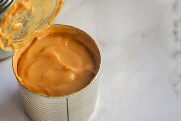 fresh Dulce de leche made from canned condensed milk on marble table