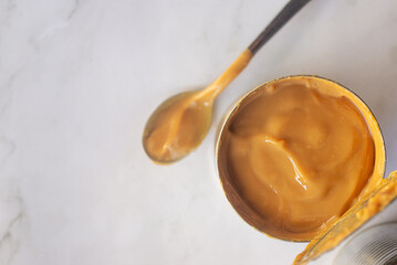 fresh Dulce de leche made from canned condensed milk on marble table
