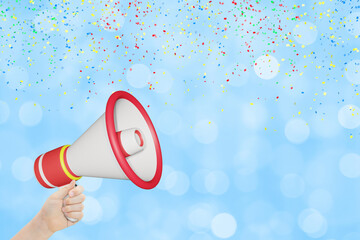 Womans hand holding  megaphone on blurred blue festive background with confetti