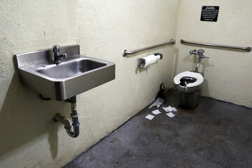 Interior of Public Restroom with Stainless Steel Fixtures and Unsanitary Conditions