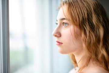 beautiful young woman in the bedroom close to a window