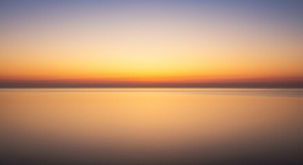 Obraz premium Serene Sunset Over Calm Ocean Water