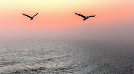 Fototapeta premium Flock of Birds Flying in Pink Sunset Sky Over the Water with Hazy View