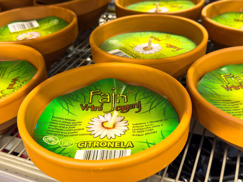 Citronella outdoor candles on metal display shelf for mosquito repellent