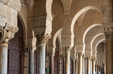 Long narrow passages under arches of temple, courtyard of great Mosque of Uqba in Tunisia. Muslim architecture, ancient religious buildings that have survived to present day © JackF