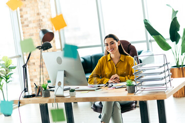 Qualified woman in a modern office setting with stylish decor, sitting at a desktop workspace,...