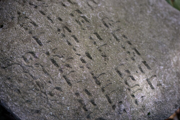 Surface of Historic Stone with Carved Symbols — Horizontal Texture Scene with Unknown Inscription
