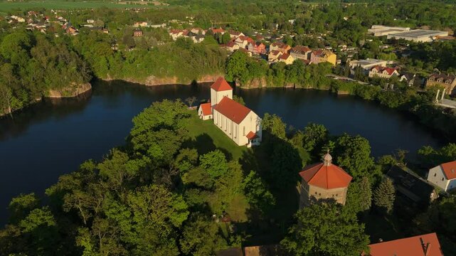 Drone shot of Beucha&rsquo;s iconic cliffside church with full view of the flooded quarry and nearby town. Captured at golden hour, the landscape combines architecture, water and nature.