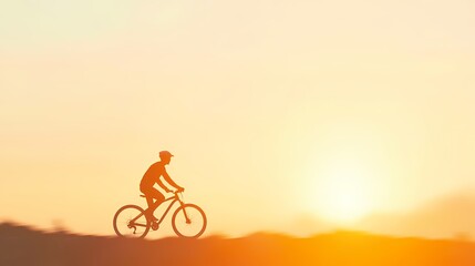 Obraz premium Silhouette of a person cycling at sunset. Concept of freedom, adventure, healthy lifestyle, and outdoor activity.
