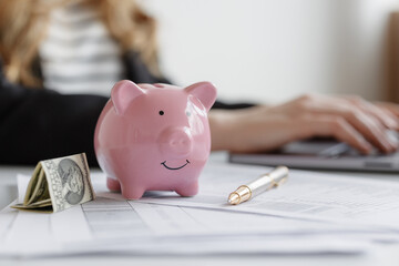 Saving money with a piggy bank and financial documents on a desk in a bright home office setting