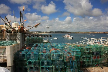 Fishing baskets are neatly stacked on the quay wall