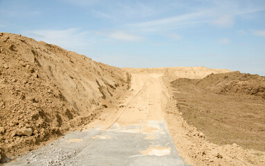 Construction site and agriculture field. Preparation of a wind turbines with concrete and steel. building wind turbines. wind turbine base and Pile of sand and Gravel for construction.